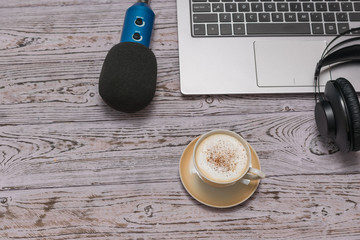 Headphones, laptop and a Cup of coffee on a toned wooden table. Job.