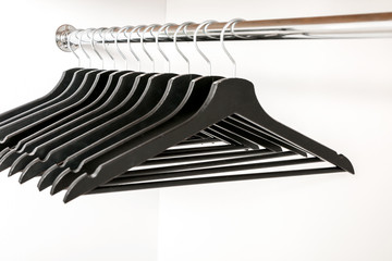 Rack with clothes hangers on white background