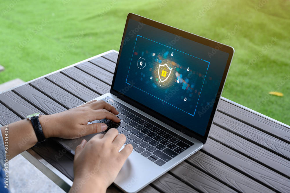 Poster person using a laptop computer with data protection, cyber security, information safety and encrypti