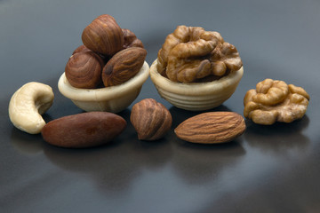 Different nuts in a waffle basket on a gray background. Vitamin wholesome food.