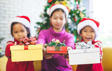 Fototapeta na wymiar Asian children holding beautiful gift boxes and giving in Christmas celebration