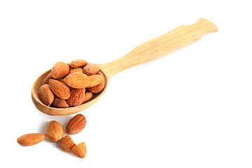 Spoon with tasty almonds on white background