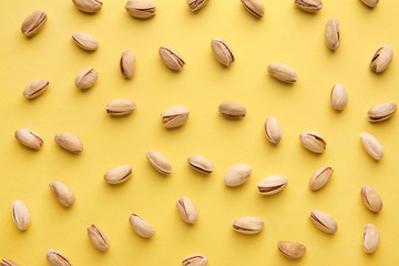 Tasty pistachio nuts on color background