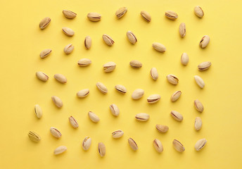 Tasty pistachio nuts on color background