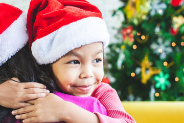 Cute asian child girl hugging her mother with love in Christmas celebration