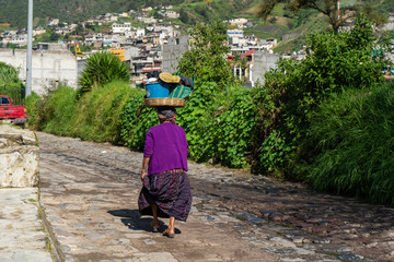 Fototapeta na wymiar Una señora maya camina en una calle en el campo de Almolonga en Guatemala.