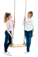 Mom and daughter swinging on a swing.