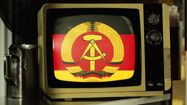 Flag of the German Democratic Republic (East Germany) on a Retro TV. Iron Curtain and Berlin Wall Concept.