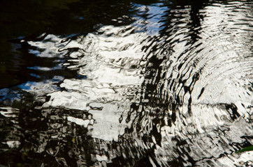 Water with waves reflecting the white and blue sky
