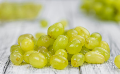 Wooden table with White Grapes (detailed close-up shot; selective focus)