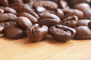 pile of roasted coffee beans on wood table. Selective focus..