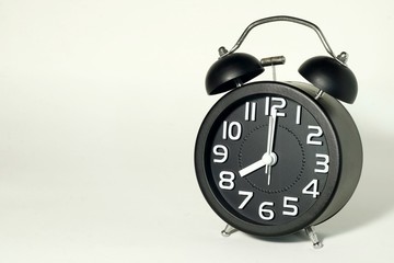 Alarm clock on white background, showing time at 8 O'clock, it's late now.