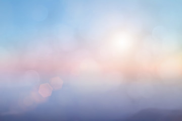 Natural background blurring warm colors and bright sun light. Bokeh or Christmas background Green Energy at sky sunny color orange light patterns plain abstract flare evening clouds blur.