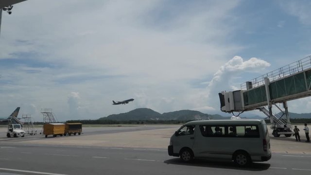 D&agrave; Nang, Hai Chau District / Vietnam - 30.05.2019 Various airport service equipment passes by camera with a view of the runway, airplanes, flight bridge, mountains and clouds.