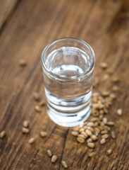 Some fresh Wheat Liqueur on wooden background (selective focus; close-up shot)