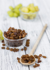 Portion of healthy Raisins on an old wooden table (selective focus; close-up shot)