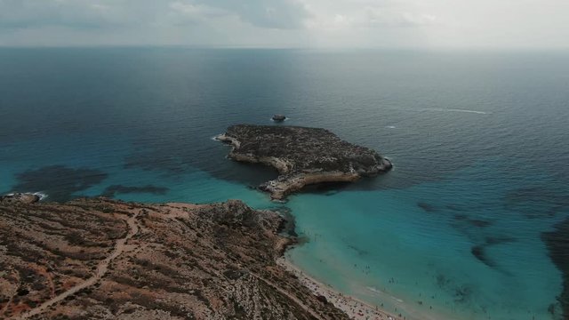 Aerial pull out view of the famous beach isola dei conigli in Lampedusa, Italy
