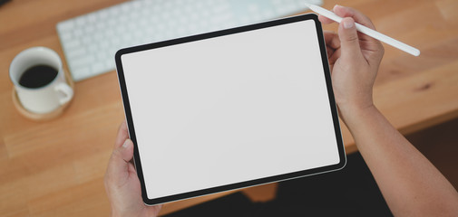 Cropped shot of young man holding blank screen tablet
