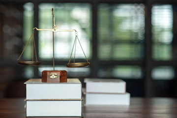 A close up of legal books with justice on the courtroom table