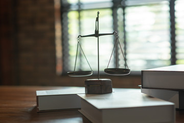 A close up of legal books with justice on the courtroom table