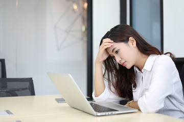 Asian business women using notebook and  serious and headache for working