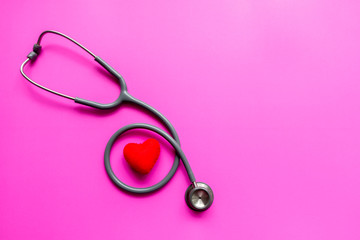 Stethoscope on a pink background with space for text.