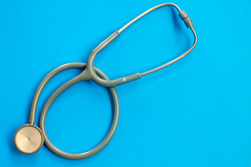 Stethoscope on a blue background with space for text.