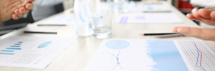 Business chart lie on table against group people