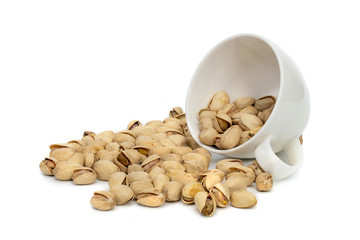 Closeup pistachios nut dry roasted and salted in a white coffee cup  isolated on white background