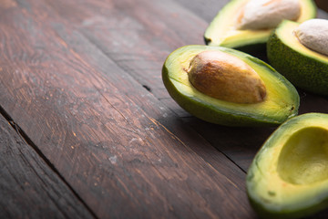 Fresh organic avocado halves on old wooden table background.Healthy food concept with copy space.