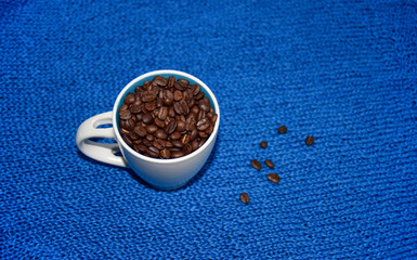 coffee beans in the white cup on the blue background