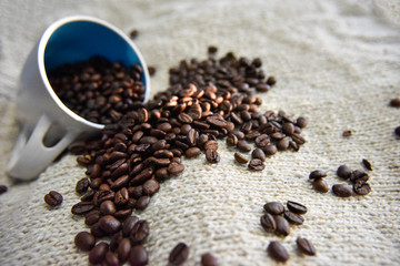 coffee beans in the white cup on the beige background