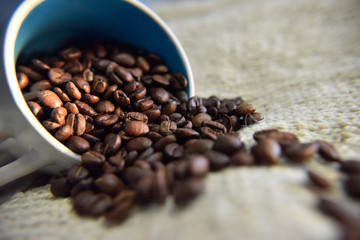 coffee beans in the white cup on the beige background