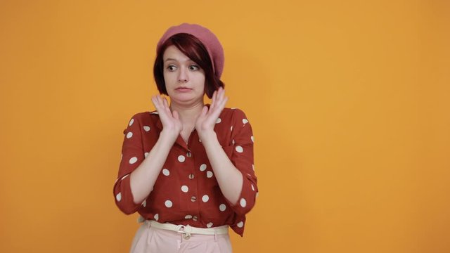 Beautiful young woman wearing red shirt in white polka dot over isolated background, displeased and fearful doing disgust face because aversion reaction. With hands raised. Annoying concept.