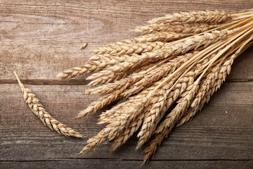 Wheat ears bunch on rustic wooden background.