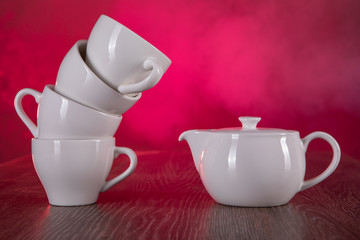 a clean white Cup, with a teapot on the table
