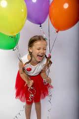 the little girl laughs out loud holds in hands balloons, funny girl