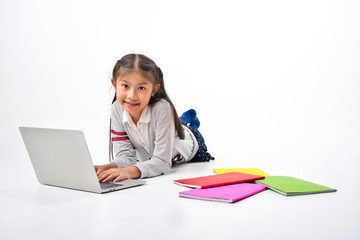 Asian Little kid with pile of books and laptop lying on white background, Education Learning School Concept