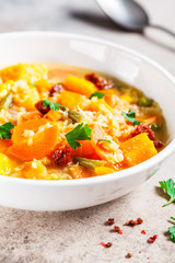 Vegetarian vegetable soup with lentils and pumpkin in white plate, copy space. Healthy vegan food concept.