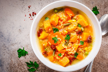 Vegetarian vegetable soup with lentils and pumpkin in white plate, top view. Healthy vegan food concept.