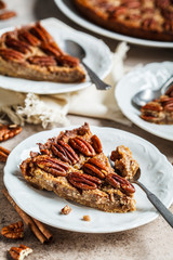 Piece of pecan Pie on gray-brown background. Vegan dessert concept.