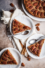 Pecan pie pieces on gray-brown background, flat lay. Vegan dessert concept.