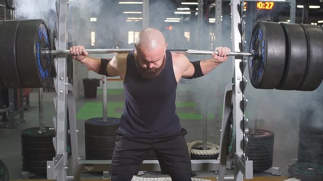 Strong active powerlifter attempting to lift heavy barbell row workout concept, portrait