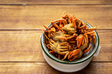 Deep-fried prawns and small crabs fried on a wooden table, Crispy fried shrimp placed on a wooden table , assortment of fried seafood on the table,Fried crab
