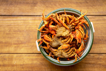Deep-fried prawns and small crabs fried on a wooden table, Crispy fried shrimp placed on a wooden table , assortment of fried seafood on the table,Fried crab