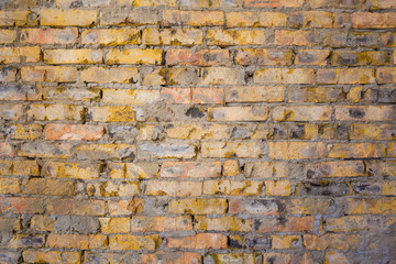 Background of old antique dirty brick wall with peeling plaster, texture