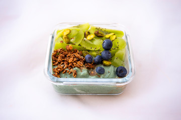 Spirulina smoothie bowl with green fruit and blueberry