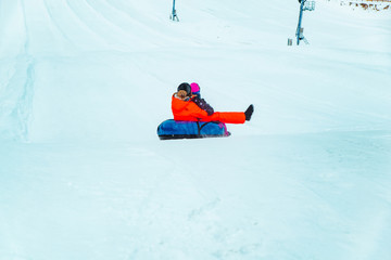 Fototapeta na wymiar people having fun. snow tubing down by winter hill