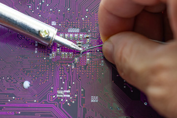 Technicians are using a soldering iron for repairing electronic