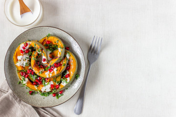 Grilled pumpkin with pomegranate and white sauce. Healthy eating.
